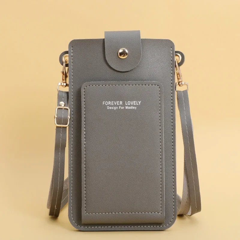 Gray crossbody bag with 'Forever Lovely' branding on a beige background